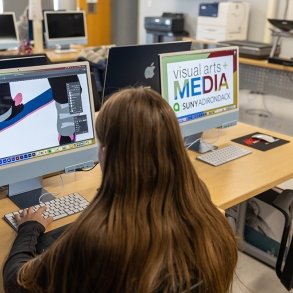 Student working on a MAC computer in Adobe Illustrator