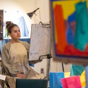 A student paints in an art class