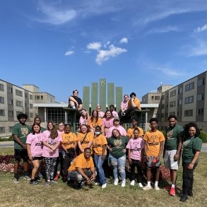 EOP students are seen sitting on the giant Adirondack chair outside the Residence Hall