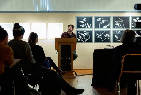 Writers Project speaker, Doug Salati speaking to a crowd in the gallery